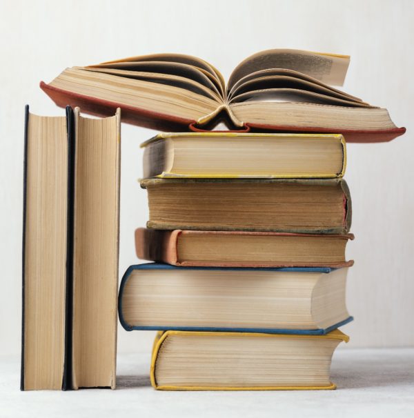 front-view-of-stack-of-books-with-one-open